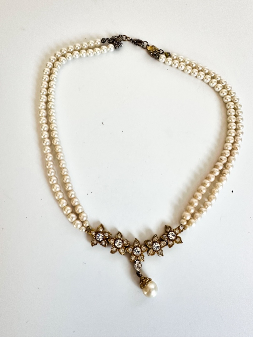 Vintage double-strand faux pearl necklace featuring an antique gold-tone floral